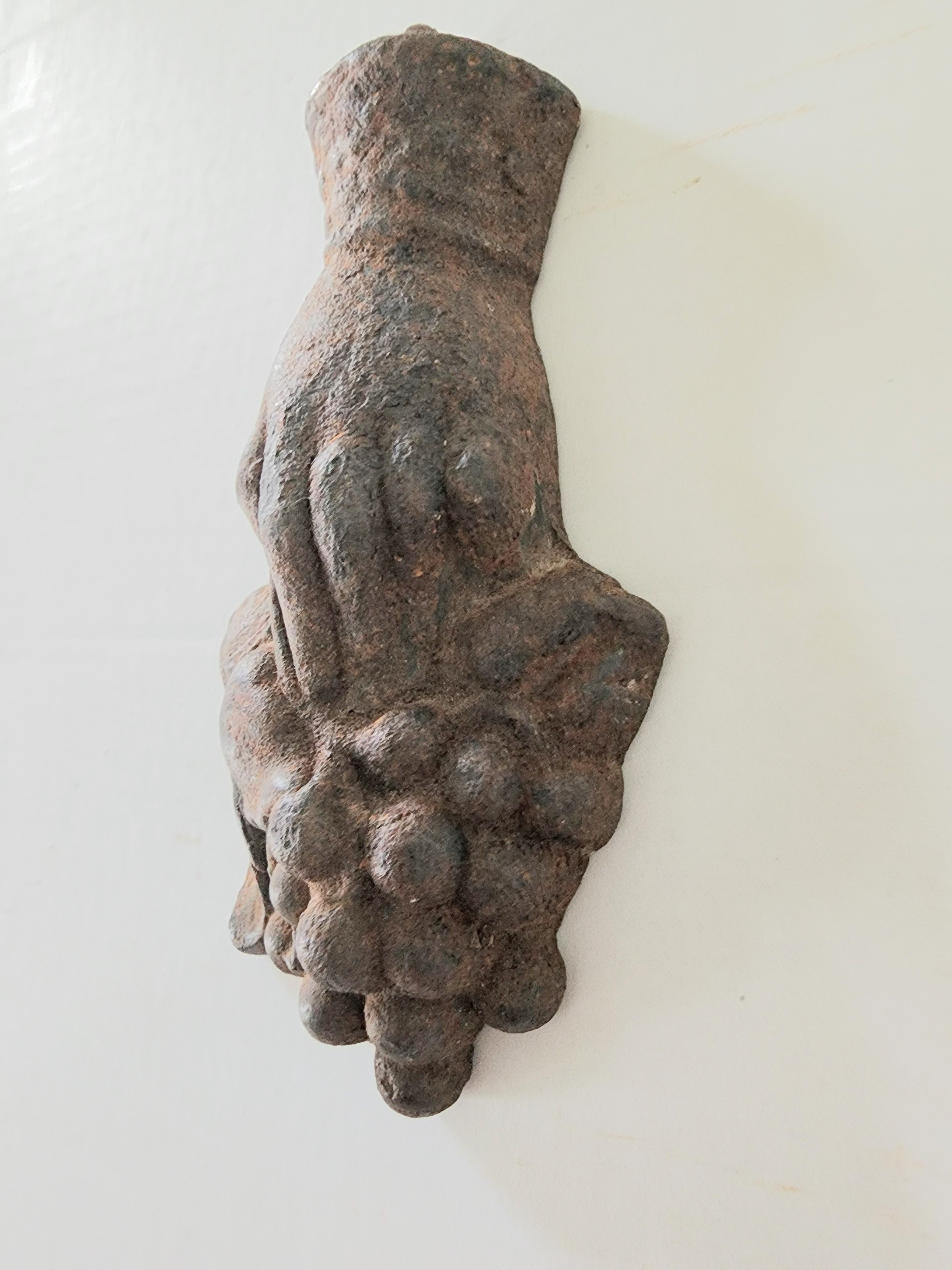 CAST IRON HAND HOLDING GRAPES