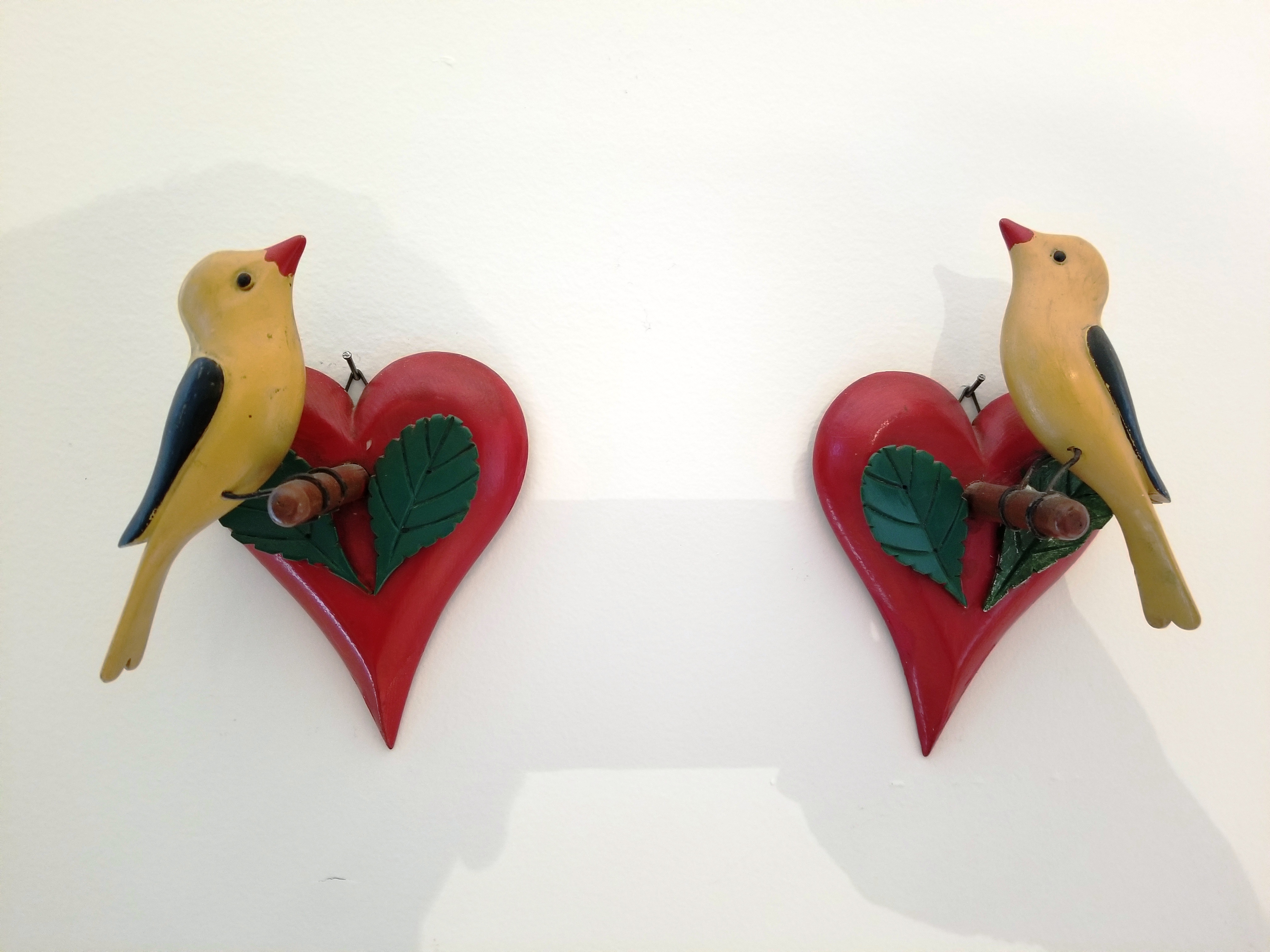 A PAIR OF WOOD CARVED FINCHES ON HEART